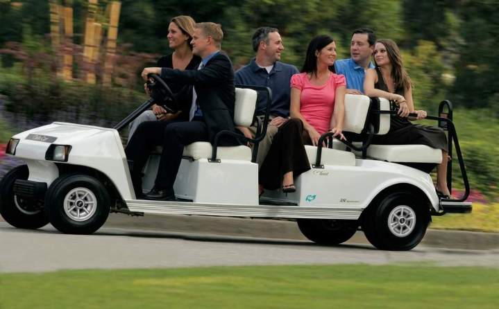 Driving white golf cart Kendall